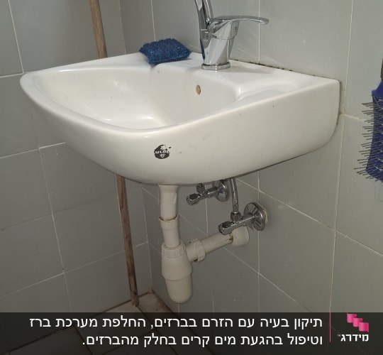 כיור עם ברז וצנרת בחדר אמבטיה